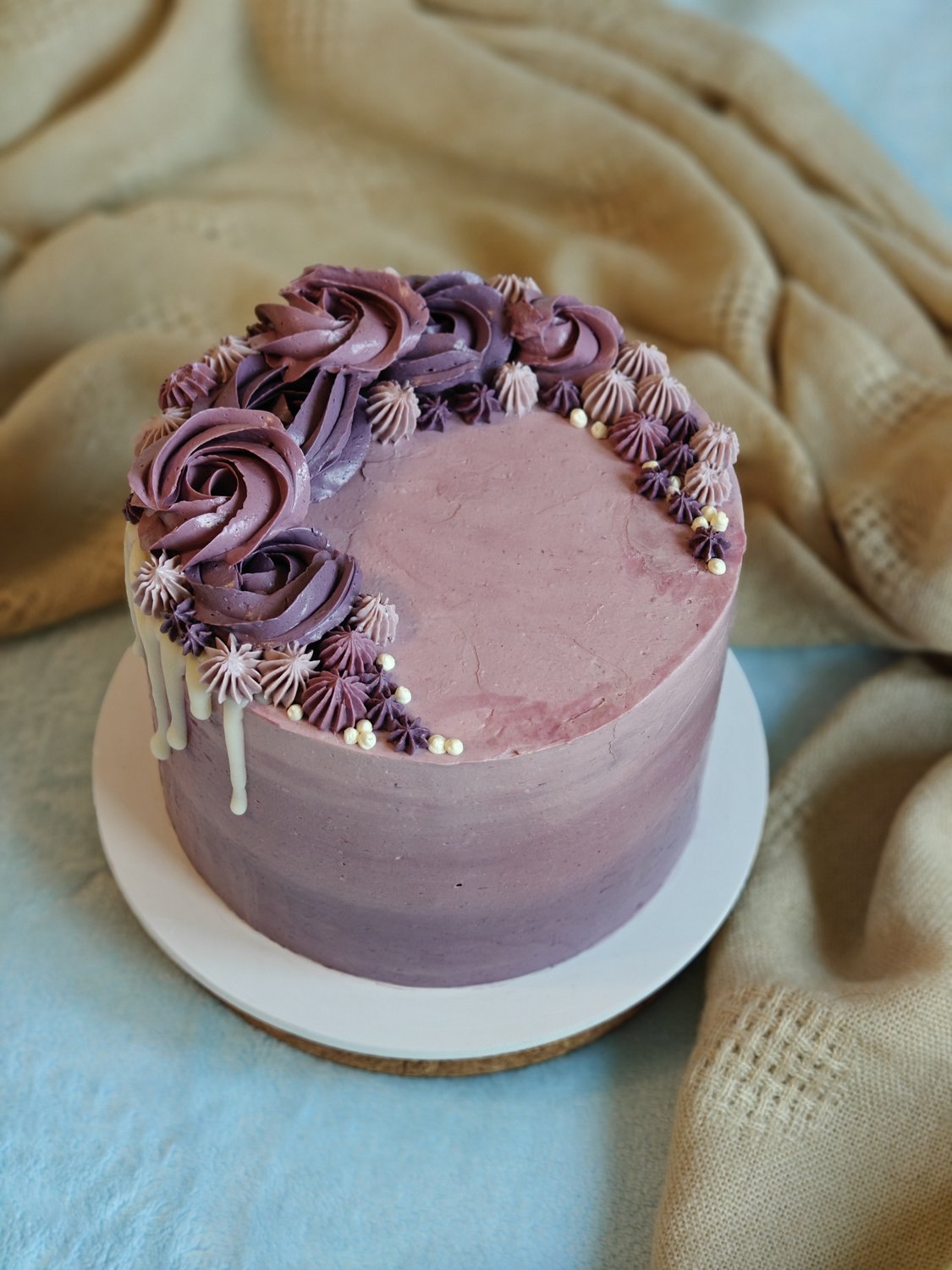Soft mauve cake with cream rosettes and rosebuds